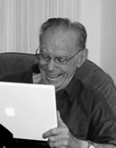 Glad äldre man som använder en dator
